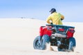 Tourist enjoy riding the quad bike or powerful fast off-road four-wheel drive ATVs at white sand dunes