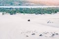 Tourist enjoy riding the quad bike or powerful fast off-road four-wheel drive ATVs at white sand dunes