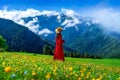 Tourist enjoy view of green pasture and flowers near snow mountain in Georgia