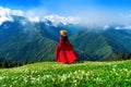 Tourist enjoy view of green pasture and flowers near snow mountain in Georgia