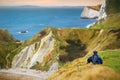 Tourist enjoying view of Man O`War Cove on the Dorset coast in southern England, between the headlands of Durdle Door to the west Royalty Free Stock Photo