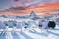 Tourist enjoying view of Matterhorn while sitting on chairs during sunset