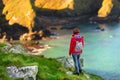 Tourist enjoying view of rugged Cornish coastline near Port Isaac historic fishing village on sunny morning, Cornwall, England