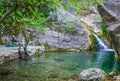 The tourist enjoys views of the small picturesque waterfall.