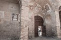 Tourist enters through large wooden doors into arched interior w