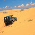 Tourist escapade Yellow sand dunes with a Jeep car Royalty Free Stock Photo