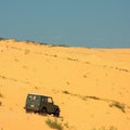 Tourist escapade Yellow sand dunes with a Jeep car Royalty Free Stock Photo