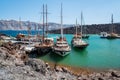Tourist excoursion boats at small port on volcano of Santorini island