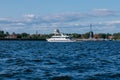 A tourist or excursion ship sails in the waters of the Gulf of Finland, the dome of the naval Cathedral in Kronstadt