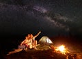 Tourist family with daughter having a rest in mountains at night under starry sky with Milky way Royalty Free Stock Photo