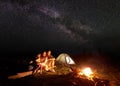 Tourist family with daughter having a rest in mountains at night under starry sky with Milky way Royalty Free Stock Photo