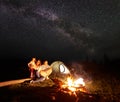 Tourist family with daughter having a rest in mountains at night under starry sky with Milky way Royalty Free Stock Photo