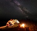 Tourist family with daughter having a rest in mountains at night under starry sky with Milky way Royalty Free Stock Photo