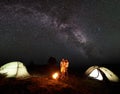 Tourist family with daughter having a rest in mountains at night under starry sky with Milky way Royalty Free Stock Photo