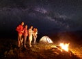 Tourist family with daughter having a rest in mountains at night under starry sky with Milky way Royalty Free Stock Photo