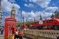 Tourist family taking a photo in fornt of a red traditional telephone booth in London with Big Ben Clock Tower and the Parliament Royalty Free Stock Photo