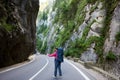 Tourist female is catching car on road in Bicaz Gorge
