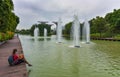 Tourist female sitting on the wooden walkway by the river in Gardens by the Bay with Supertrees in the background, Singapore Royalty Free Stock Photo