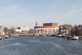 Tourist ferry in Amsterdam canal close to opera house editorial stock picture