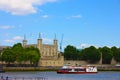 A tourist ferry transports tourists along the Thames river between the buildings and historic buildings of London