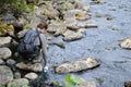 Tourist filling the bottle with water from river. Royalty Free Stock Photo