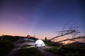 Tourist with flashlight near his camp tent at night Royalty Free Stock Photo