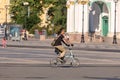 A tourist on a folding bike rides through the town square Royalty Free Stock Photo