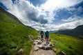 Tourist friends on a top of mountains in a Scottish Highlands. Scotland nature. Tourist people enjoy a moment in a nature. Touris