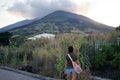 Tourist girl admiring the volcano Stromboli in the evening in Sicily, Italy