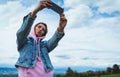 Tourist girl on background blue sky clouds taking photo selfie on mobile smart phone, person looking on camera gadget technology Royalty Free Stock Photo
