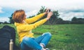 Tourist girl on background green grass taking photo selfie on mobile smart phone, person looking on camera gadget technology, blog Royalty Free Stock Photo