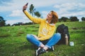Tourist girl on background green grass taking photo selfie on mobile smart phone, person looking on camera gadget technology, blog Royalty Free Stock Photo