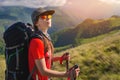 A tourist girl with a backpack admires the sunset from the mount Royalty Free Stock Photo