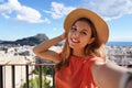 Tourist girl on Castillo de San Fernando taking selfie photo with Alicante cityscape and Mount Benacantil with Castillo de Santa