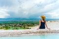 Tourist girl in dress with hat in Natural travertine pools and terraces in Pamukkale. Cotton castle in Turkey. Woman in pamukkale.