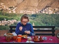 Tourist girl eat traditional moroccan breakfast at a rooftop terrace