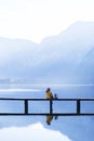 Tourist girl in a hat and with a backpack sitting on a wooden bridge Royalty Free Stock Photo