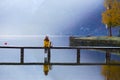 Tourist girl in a hat and with a backpack sitting on a wooden bridge Royalty Free Stock Photo