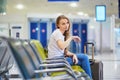 Tourist girl in international airport, waiting for her flight, looking upset Royalty Free Stock Photo