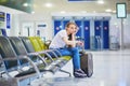 Tourist girl in international airport, waiting for her flight, looking upset Royalty Free Stock Photo