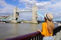 Tourist girl leaning on the railing on River Thames promenade with Tower Bridge famous landmark in London, UK Royalty Free Stock Photo