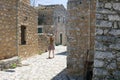 tourist girl raises het arms in the ancient streets of areopolis in greece on mani peninsula of peloponnese Royalty Free Stock Photo