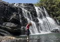 Tourist girl standing near the huge beautiful waterfall