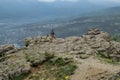 A tourist girl standing on a rock and admires the Demerdzhi mountain range on the Crimean peninsula
