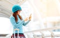 Tourist girl with suitcase use mobile phone in the train station Royalty Free Stock Photo