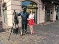 Tourist girl in sunglasses stands near the statue of the painter Ignac Roskovics in Uzhgorod