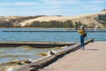 Tourist girl taking photos of the desert dunes of the Curonian Spit in Nida Royalty Free Stock Photo