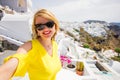 Tourist girl taking selfie in beautiful Santorini island.