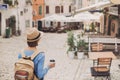 Tourist girl walking in the city during vacation. Cheerful woman traveling abroad in summer. Travel and active lifestyle concept