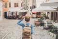 Tourist girl walking in the city during vacation. Cheerful woman traveling abroad in summer. Travel and active lifestyle concept